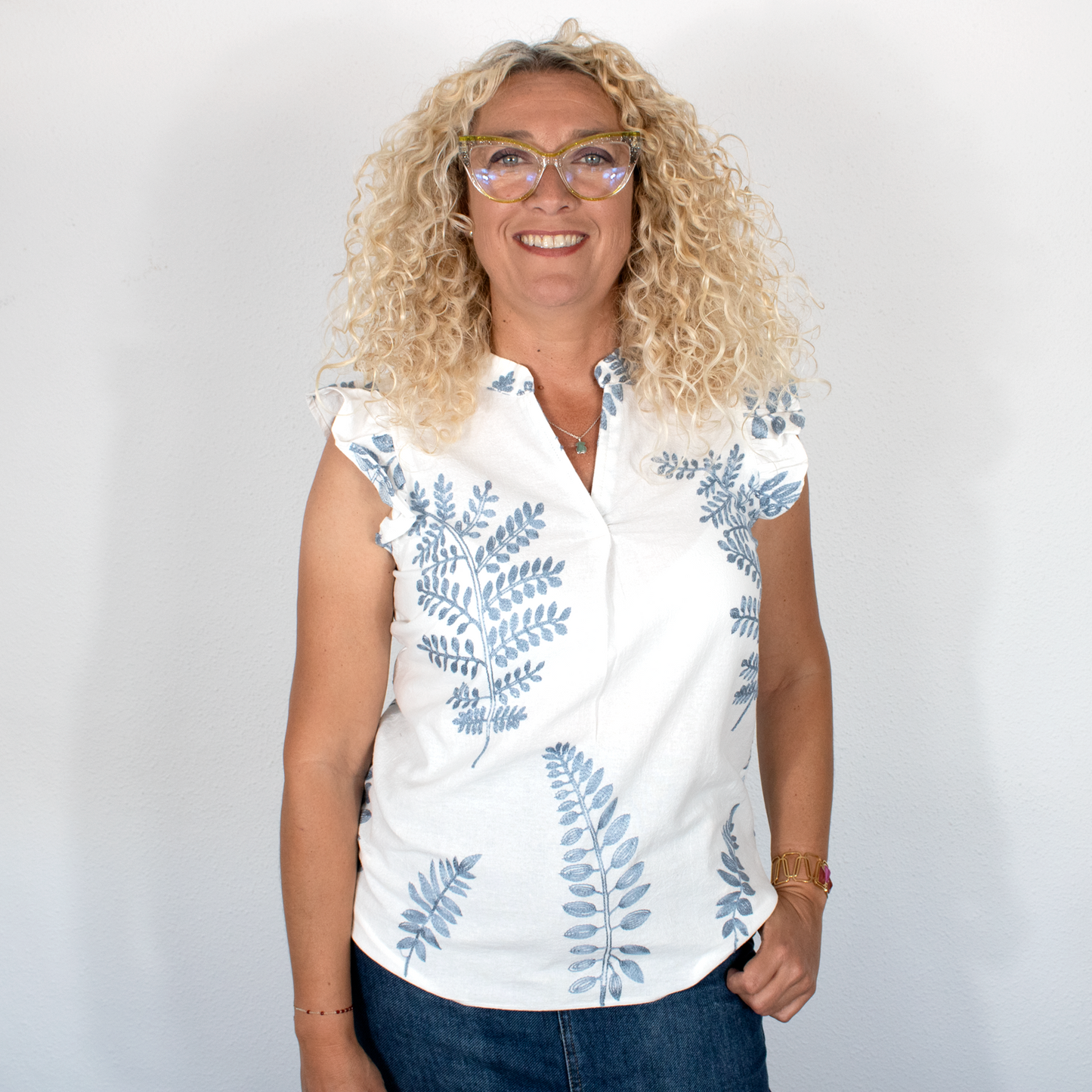 Blusa blanca con hojas azules, cuello mao y mangas volantes