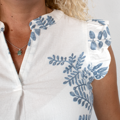 Blusa blanca con hojas azules, cuello mao y mangas volantes