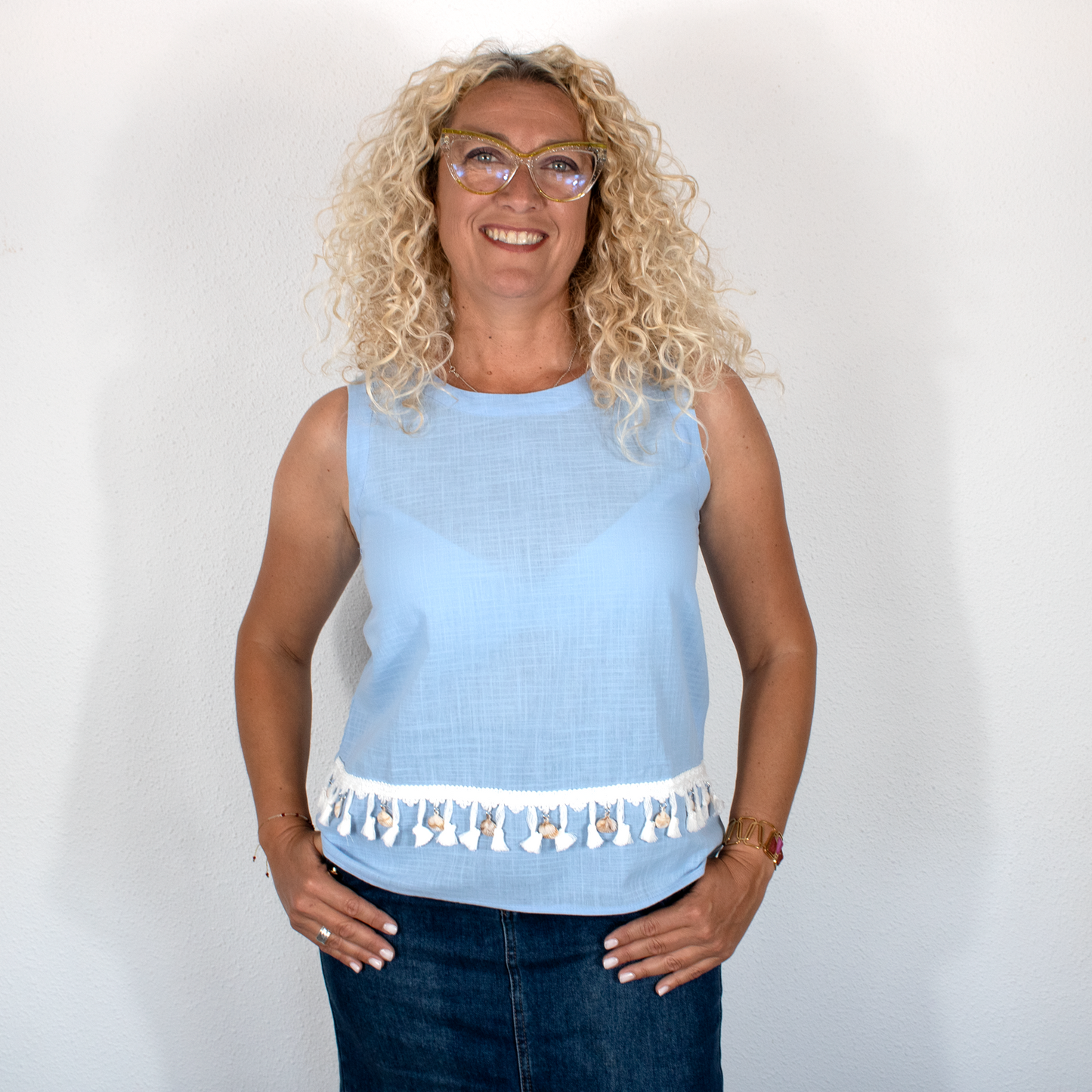 Blusa celeste con detalles decorativos, encaje y borlas