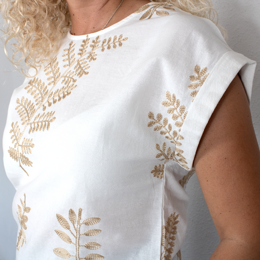 Blusa blanca con hojas doradas y cuello redondo