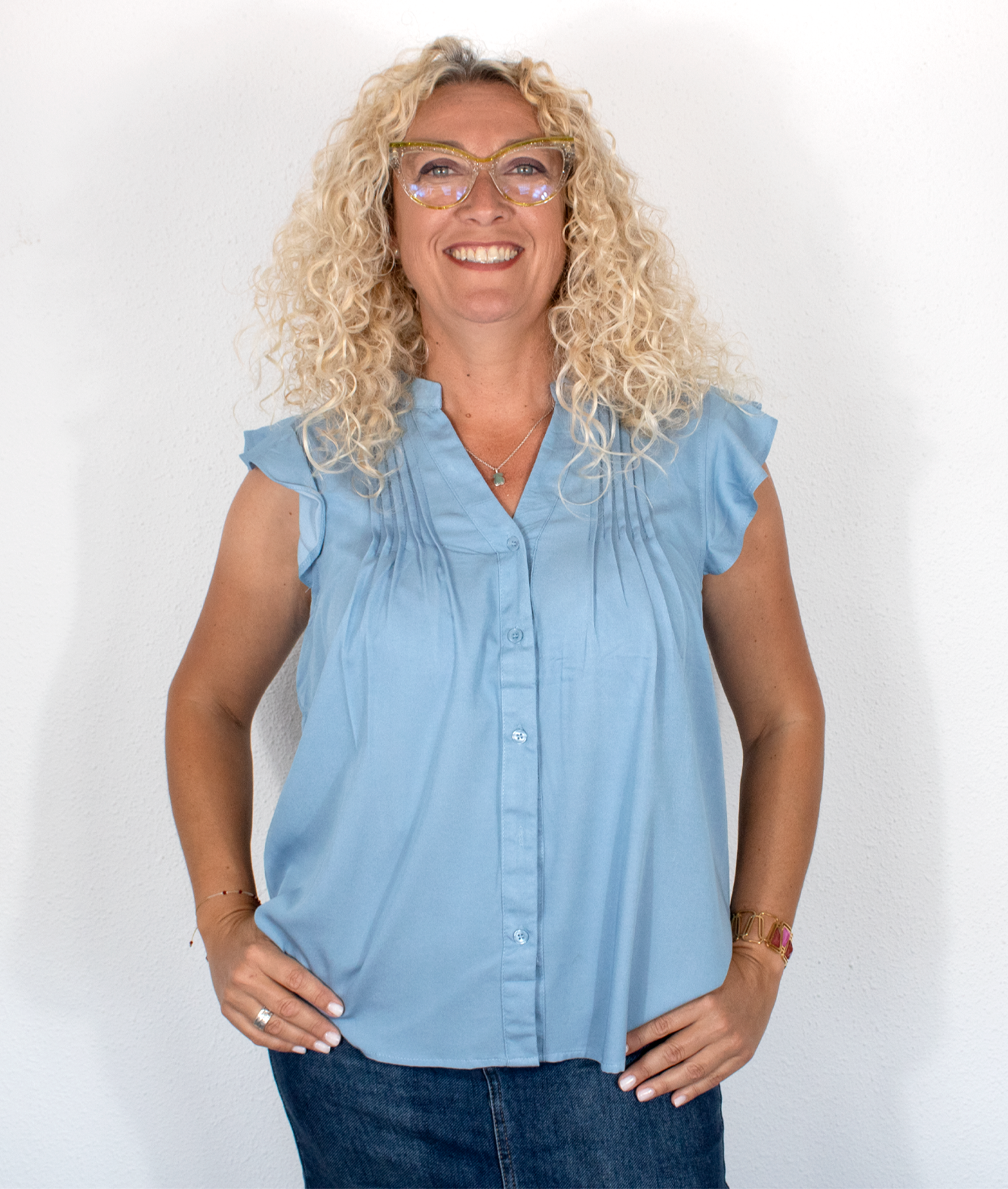 Blusa azul con pliegues frontales y mangas volantes
