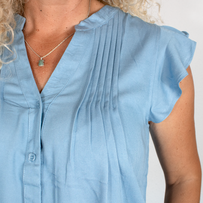 Blusa azul con pliegues frontales y mangas volantes