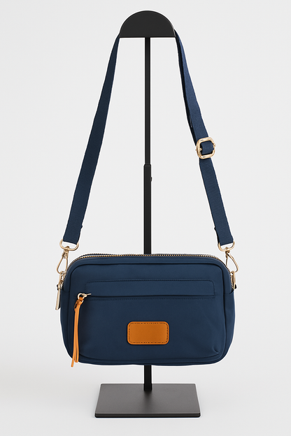 Bolso bandolera azul marino con bolsillo frontal y detalles en marrón
