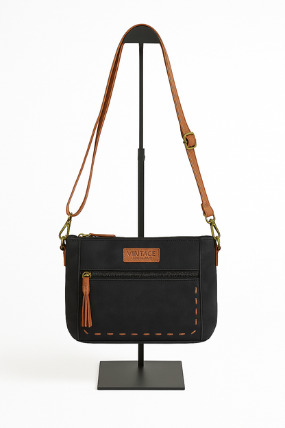 Bolso bandolera negro con cremallera frontal y detalles en marrón