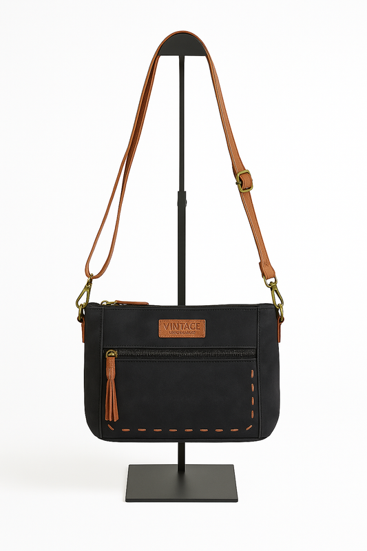 Bolso bandolera negro con cremallera frontal y detalles en marrón